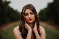 a beautiful young woman posing in a field