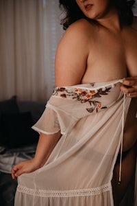a woman in a white robe posing on a bed