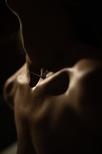 a close up of a woman's neck in the dark